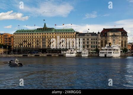 Looking across Norrstrom River to Södra Blasieholmshamnen a riverside street housing the Grand Hotel Mathias Dahlgren - Matbaren restaurant and the si Stock Photo