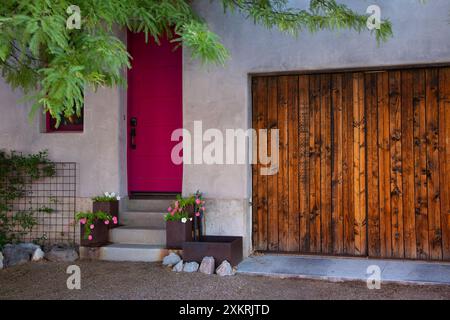 Pink red hues of front door welcome with flowers and rustic courtyard doors in Barrio Viejo, Spanish for Old Neighborhood, in Tucson, Arizona Stock Photo