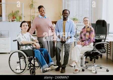 Portrait of young international IT team sitting for photo in center of light and comfort office of modern IT company Stock Photo