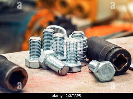 Assortment steel screws close-up. Set of bolts on blurred workshop background. Expendable hardware Stock Photo