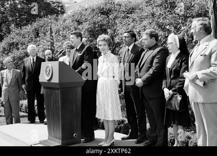 U.S. President Ronald Reagan standing at lectern with U.S. First Lady Nancy Reagan and others during National Day of Prayer ceremony, White House, Washington, D.C., USA, Chick Harrity, U.S. News & World Report Magazine Photograph Collection, May 6, 1982 Stock Photo