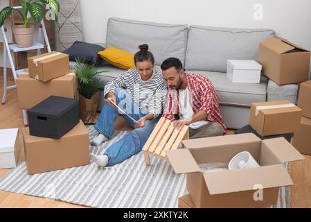 Couple assembling furniture in new apartment together Stock Photo