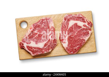 Raw marbled ribeye steaks on board. Flat lay. Isolated on white background Stock Photo