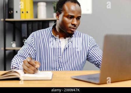 Man working on laptop at desk. Stock Photo