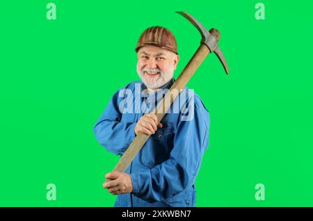 Construction worker in hard hat with pickaxe. Smiling builder man in uniform with pick-axe on shoulder. Mining industry. Mature coal miner with pickax Stock Photo