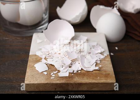 Pieces of broken eggshells on wooden table, closeup Stock Photo