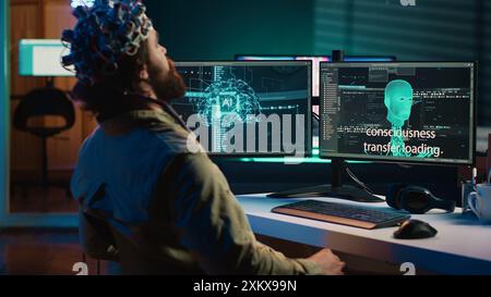 Programmer using EEG headset to upload his mind into computer, attaining immortality. Neuroscientist experimenting with transferring consciousness into cyberspace, camera A Stock Photo