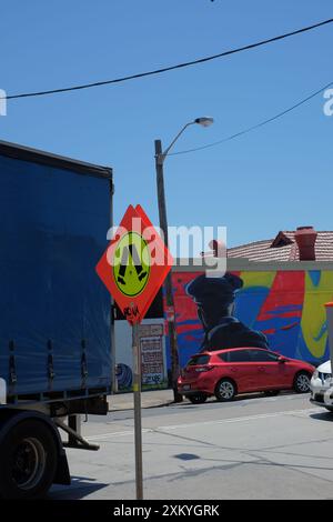 Blue truck, blue sky, Guerrilla art on a pedestrian crossing sign in the inner west Sydney, a fluro painted Walk sign, street art movement. Stock Photo
