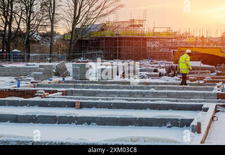 Concrete foundation for a new house in the wintertime under snow. Construction works on stop due to snow Stock Photo