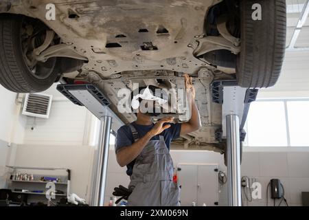 Mechanic using VR headset for 3D inspection of car in workshop Stock Photo