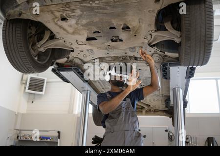 Mechanic uses virtual reality for car inspection in garage Stock Photo