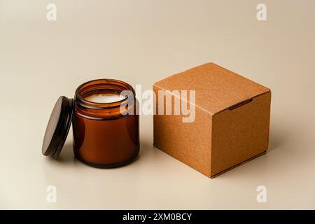 Glass Candle Jar and Cardboard Box on Beige Background Stock Photo