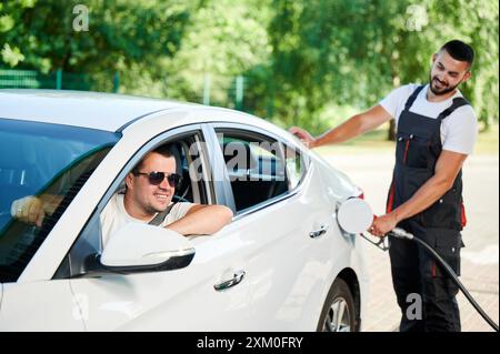 Gas station worker refilling car at service station Stock Photo - Alamy