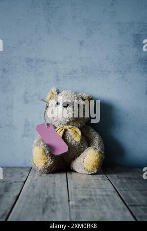 Teddy bear with a label attached. Stock Photo