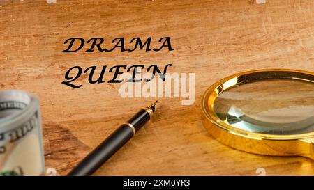 Drama queen words on papyrus in a composition with a magnifying glass, fountain pen and dollars without focus Stock Photo