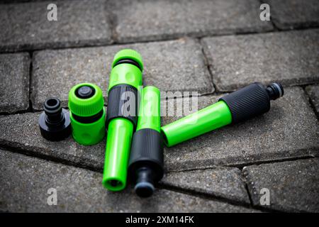 Assorted green and black garden hose connectors provide essential tools for gardeners and landscapers. Ideal for DIY irrigation setups and enhancing g Stock Photo