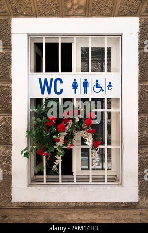 Croatian WC public toilet sign, men & women, mainly for tourists, beside a Croatian shop. Split. The lavatory facility is probably not free. Croatia. (138) Stock Photo