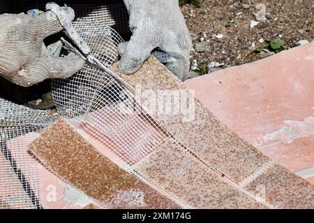 Thin fake bricks made of acrylic marble chips are reinforced with plastic mesh that can be easily cut with scissors. Stock Photo