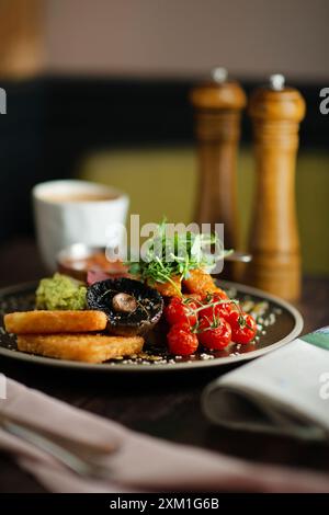 English Breakfast on a black ceramic plate. Wooden table. Full English breakfast. Stock Photo