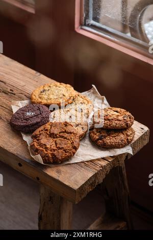 Handmade assorted cookies, chocolate chip cookies, and oats cookies, on parchment paper. Wooden table. Top view. Stock Photo