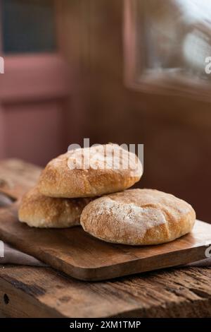 Freshly baked ciabatta, Italian bread,  on wooden cutting board. Stock Photo