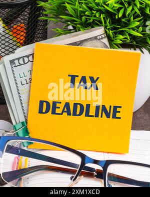 TAX DEADLINE words written on a yellow sticker on the table Stock Photo