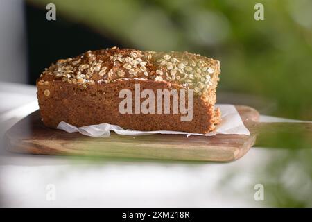 Whole Grain rye bread with seeds on a cutting board. Dark background. Stock Photo