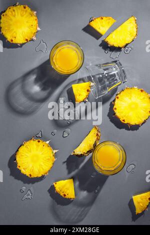 Pineapple pieces and pineapple juice isolated on grey background. Tropical holiday concept. Flat lay, top view Stock Photo