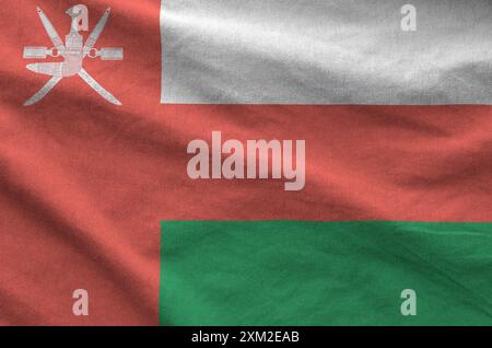 Oman flag depicted on folded wavy fabric of old cloth close up Stock Photo