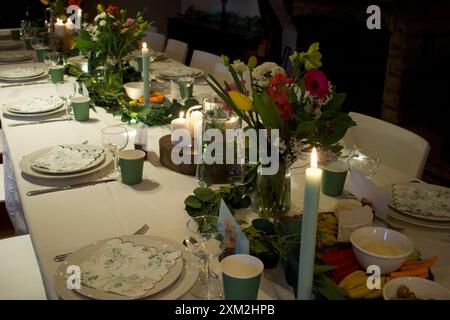 Candlelight banquet with flowers and a long white table Stock Photo