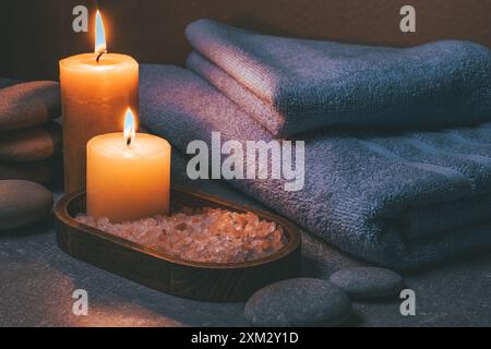 Spa still life with towels, sea salt and candles on stone background Stock Photo
