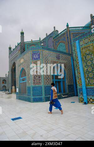 A man walks past the Shrine of Hazrat Ali, also known as The Blue Mosque, in Mazar-i-Sharif, northern Afghanistan. Stock Photo