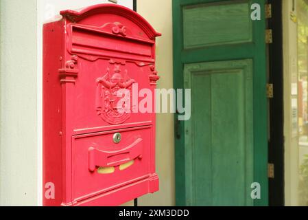 Red Postbox on the Outside Wall of a Vintage House Stock Photo