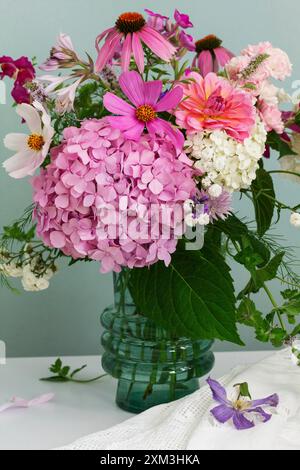 A bouquet of summer flowers in the room. Hydrangea, rose, echinacea, mint, snapdragon, asparagus and other flowers. Stock Photo