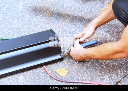 Worker cutting aluminum rain gutter with shears after bending at machine tool Stock Photo