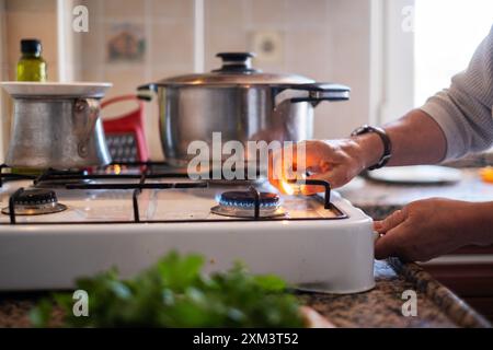 hand adjusting gas burning from a kitchen gas stove Stock Photo