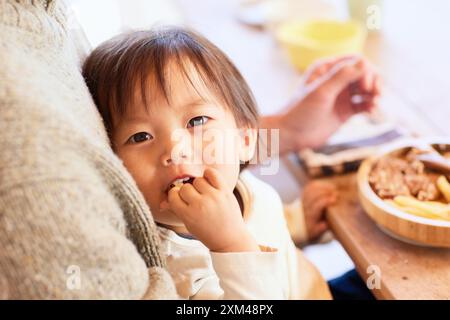 Happy Japanese kid eating in the dining room Stock Photo