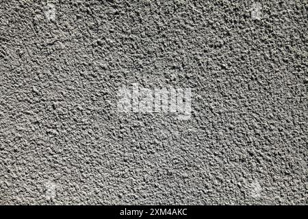 Grey cement wall, texture, background. Relief surface. Plastered building wall with rough cement coating. Decorated surface and backdrop Stock Photo