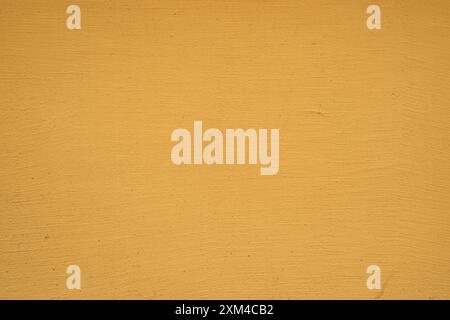 Yellow painted plaster on house wall closeup as background Stock Photo