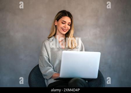 Young female designer, freelancer working in the office. Female using laptop to searching info. Stock Photo
