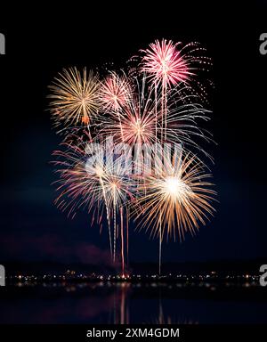Composite of Fireworks Against Black with Shoreline and Reflections Stock Photo