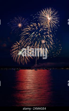 Composite of Fireworks Against Black with Shoreline and Reflections Stock Photo