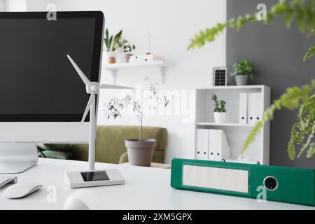 Wind turbine model with folder on engineer's table in office, closeup Stock Photo