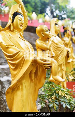 Golden Buddha statues along the stairs leading to the Ten Thousa Stock Photo