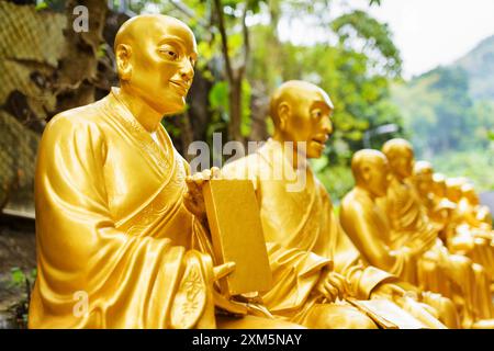 Golden Buddha statues along the stairs leading to the Ten Thousa Stock Photo