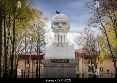 The old statue of Vladimir Lenin, a Soviet communist leader, (with word 'Lenin' in Russian) in the green park at Zhigulevsk, Russia, Samara oblast Stock Photo