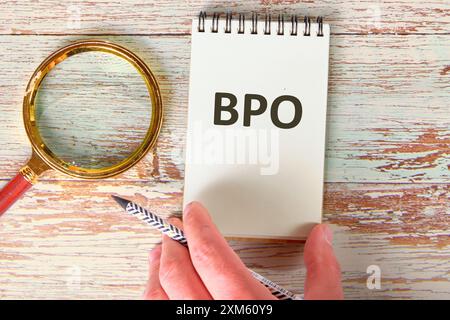 Business concept. Letters BPO. Business Process Outsourcing in the notebook next to the magnifying glass Stock Photo