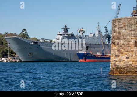 HMAS Canberra in port at Garden Island naval base with Martello tower on Fort Denison visible, Sydney harbour,New South Wales,Australia Stock Photo