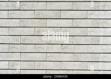 Textured surface of brickwork facade of old renovated building. Flat stone slabs patterned background. Texture of artificial brick wall  Stock Photo
