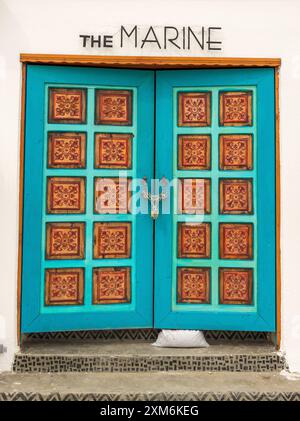 Large wooden double door with artfully painted square columns in Akyaka, Turkey. Stock Photo